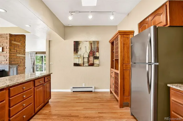 a view of kitchen with stainless steel appliances granite countertop a refrigerator and a sink