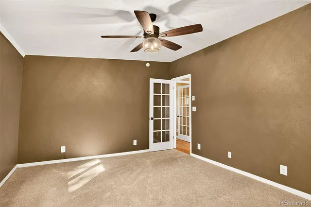 an empty room with a ceiling fan and a window