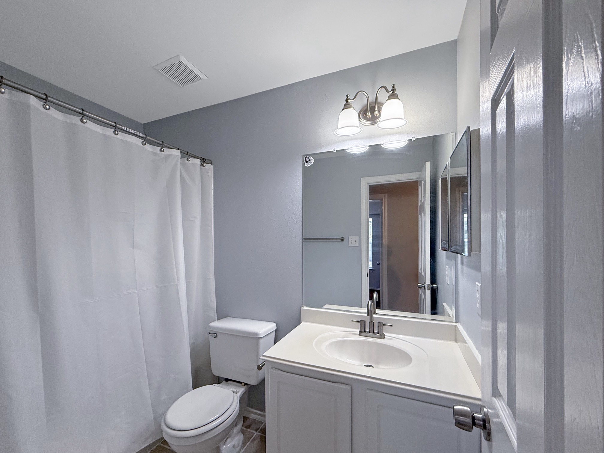 3 Peach Ridge Place The Woodlands, TX 77382 - Photo 19 of 22 a bathroom with a sink vanity mirror and toilet