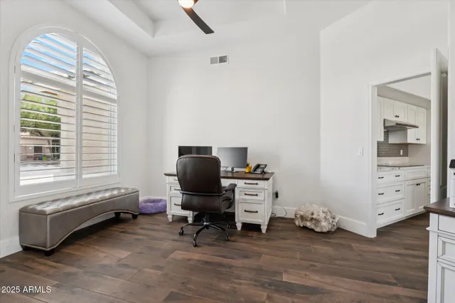a view of a workspace with furniture and a window