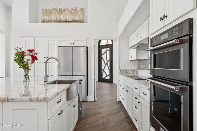 a kitchen with stainless steel appliances kitchen island granite countertop a refrigerator and a stove