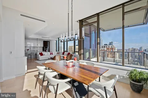 a dining room with furniture and a potted plant