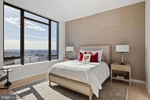 a bedroom with a large bed and a lamp next to a large window