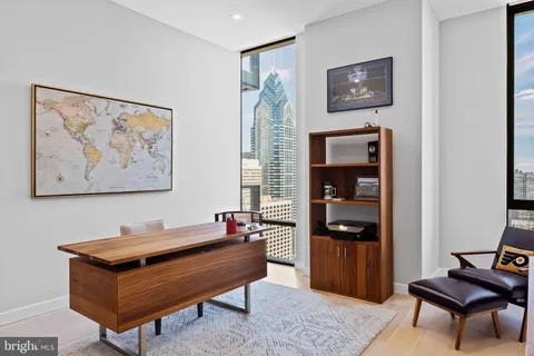 a living room with furniture and a refrigerator