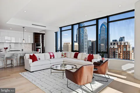 a living room with furniture and large windows