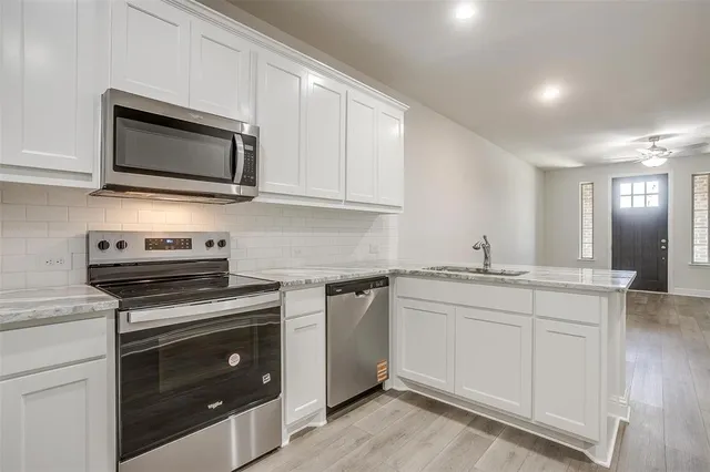 a kitchen with stainless steel appliances granite countertop a sink and a stove