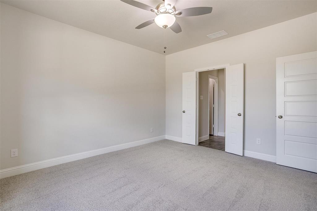 6819 Robert Reed Drive Arlington, TX 76001 - Photo 17 of 32 an empty room with closet and a chandelier fan