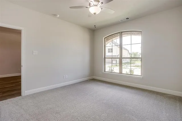 an empty room with a window and a fan