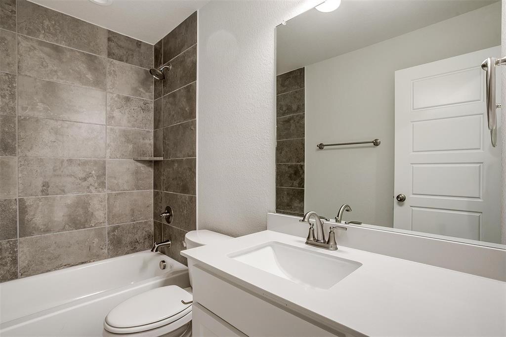 6819 Robert Reed Drive Arlington, TX 76001 - Photo 30 of 32 a bathroom with a bathtub shower sink vanity and toilet