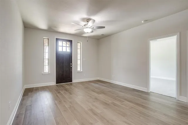 a view of an empty room with wooden floor