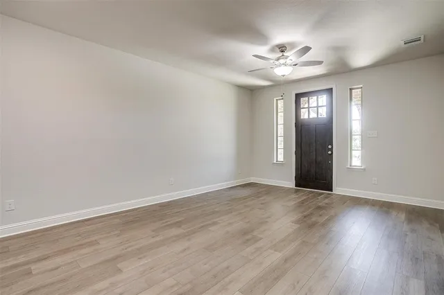 a view of an empty room with wooden floor