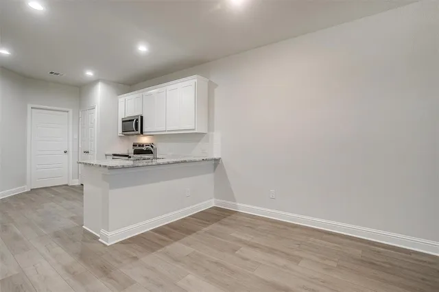 a kitchen with granite countertop white cabinets and white appliances