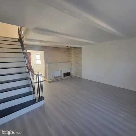 a view of a livingroom with wooden floor and stairs