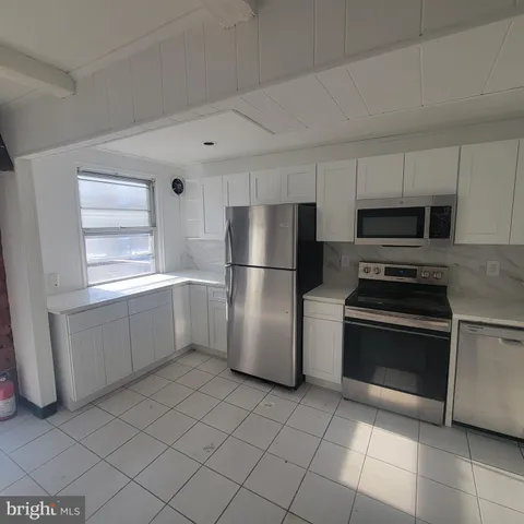 a kitchen with a refrigerator and a stove top oven