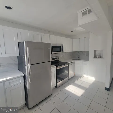 a kitchen with stainless steel appliances granite countertop a refrigerator sink and stove