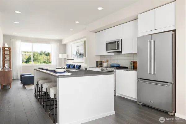 a kitchen with sink a refrigerator and wooden floor