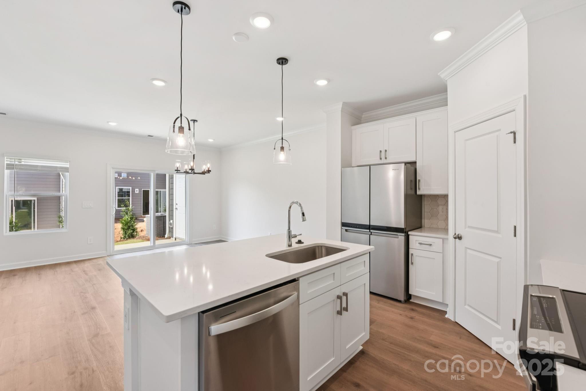 282 Tiger Lily Drive Fort Mill, SC 29708 - Photo 3 of 18 a kitchen with stainless steel appliances granite countertop a sink a refrigerator a stove a kitchen island with wooden floor and cabinets