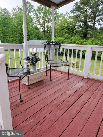 a view of a deck with table and chairs with wooden floor and fence