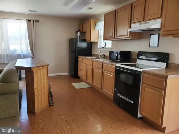 a kitchen with a sink a refrigerator and cabinets