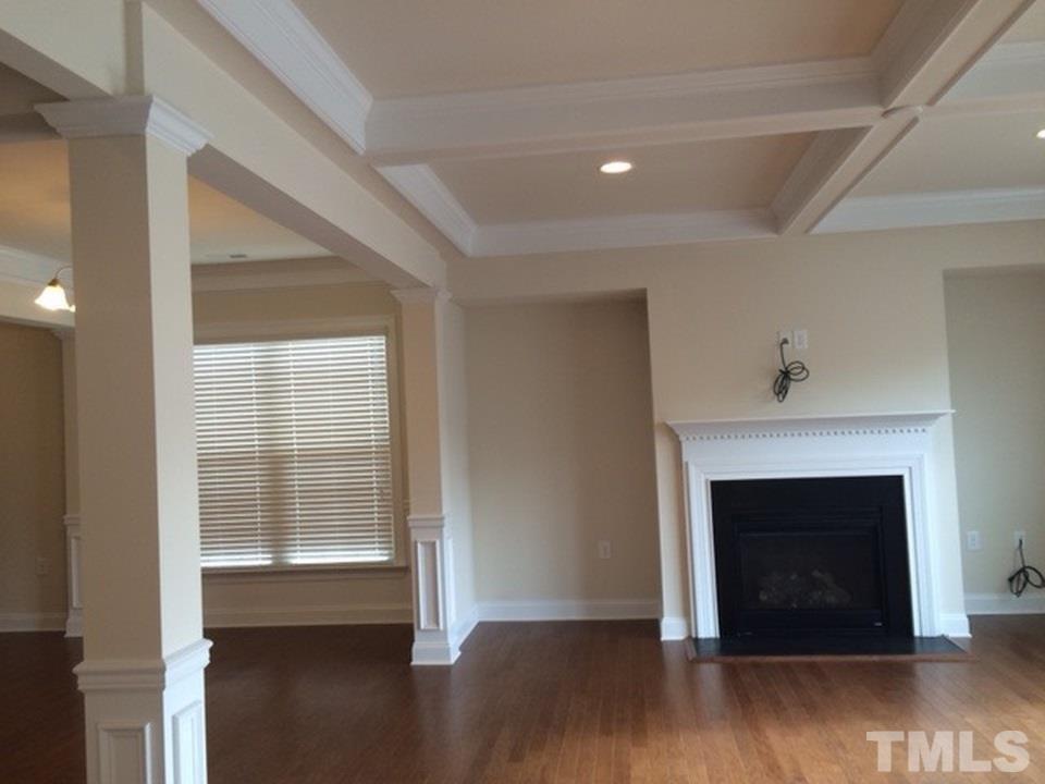 403 Bent Tree Lane Cary, NC 27519 - Photo 4 of 13 a view of an empty room with wooden floor fireplace and a window