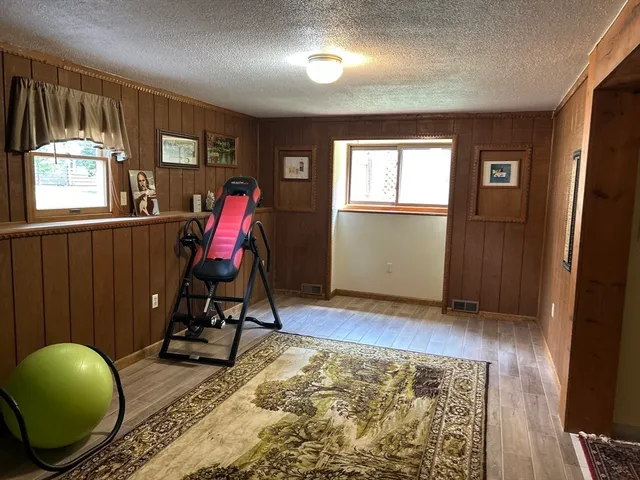 a view of a hallway with wooden floor and a bathroom