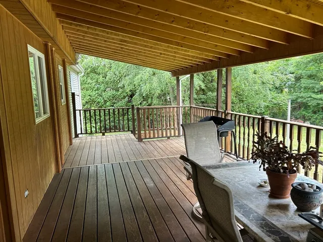 a view of a balcony with chairs and wooden floor