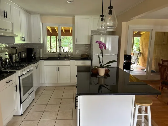 a kitchen with stainless steel appliances granite countertop a stove a sink and a microwave