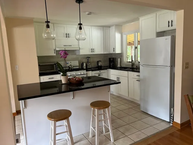 a kitchen with stainless steel appliances granite countertop a sink a refrigerator and a refrigerator