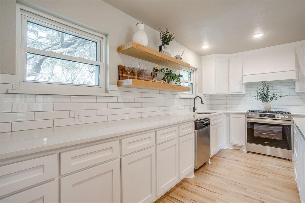 103 Vanshire Road West Lakeside, TX 76108 - Photo 12 of 39 a kitchen with granite countertop white cabinets a sink a window and stainless steel appliances