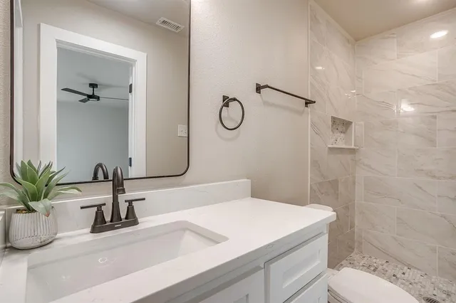 a bathroom with a sink a toilet and shower