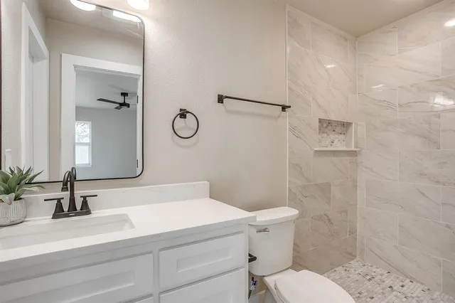 a bathroom with a sink a toilet and shower