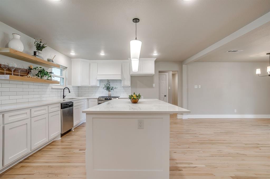103 Vanshire Road West Lakeside, TX 76108 - Photo 10 of 39 a kitchen with kitchen island a sink a stove a refrigerator and white cabinets