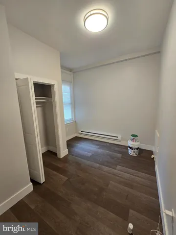 an empty room with wooden floor and closet