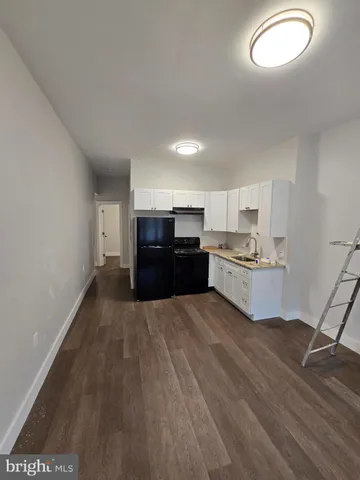 a view of kitchen with wooden floor and electronic appliances