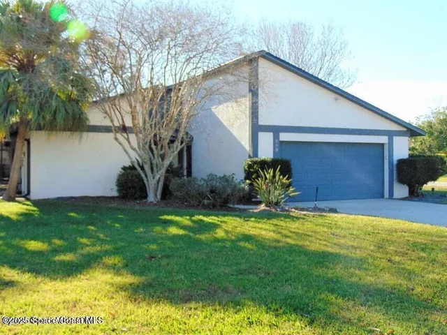 a house that has a big yard with potted plants