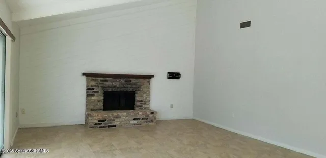 a view of an empty room with fire place