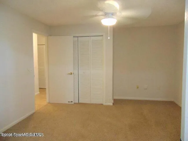 an empty room with a ceiling fan and painted walls