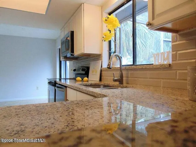 a view of living room kitchen and entryway