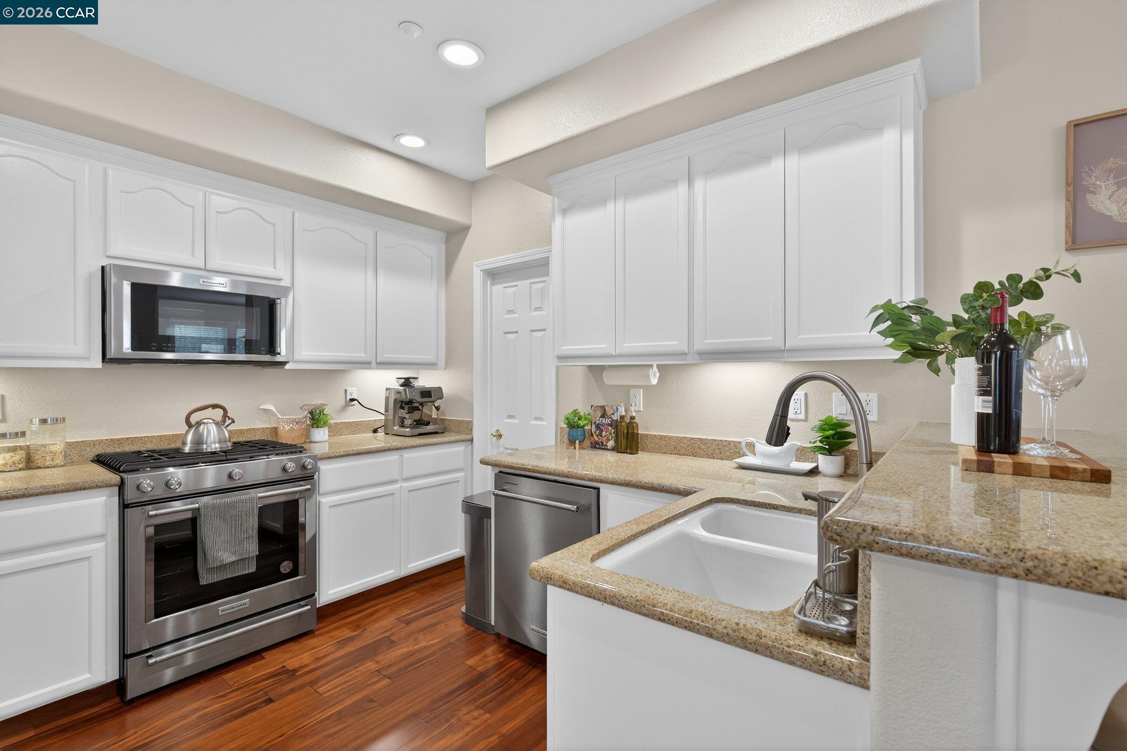 4300 Keegan Street Dublin, CA 94568 - Photo 14 of 33 a kitchen with kitchen island granite countertop a sink stainless steel appliances and white cabinets