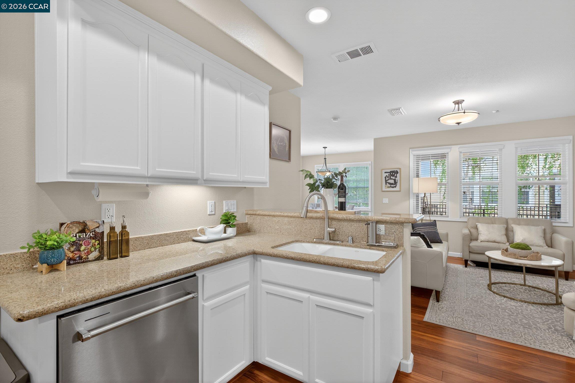 4300 Keegan Street Dublin, CA 94568 - Photo 15 of 33 a kitchen with a sink dishwasher and white cabinets with wooden floor