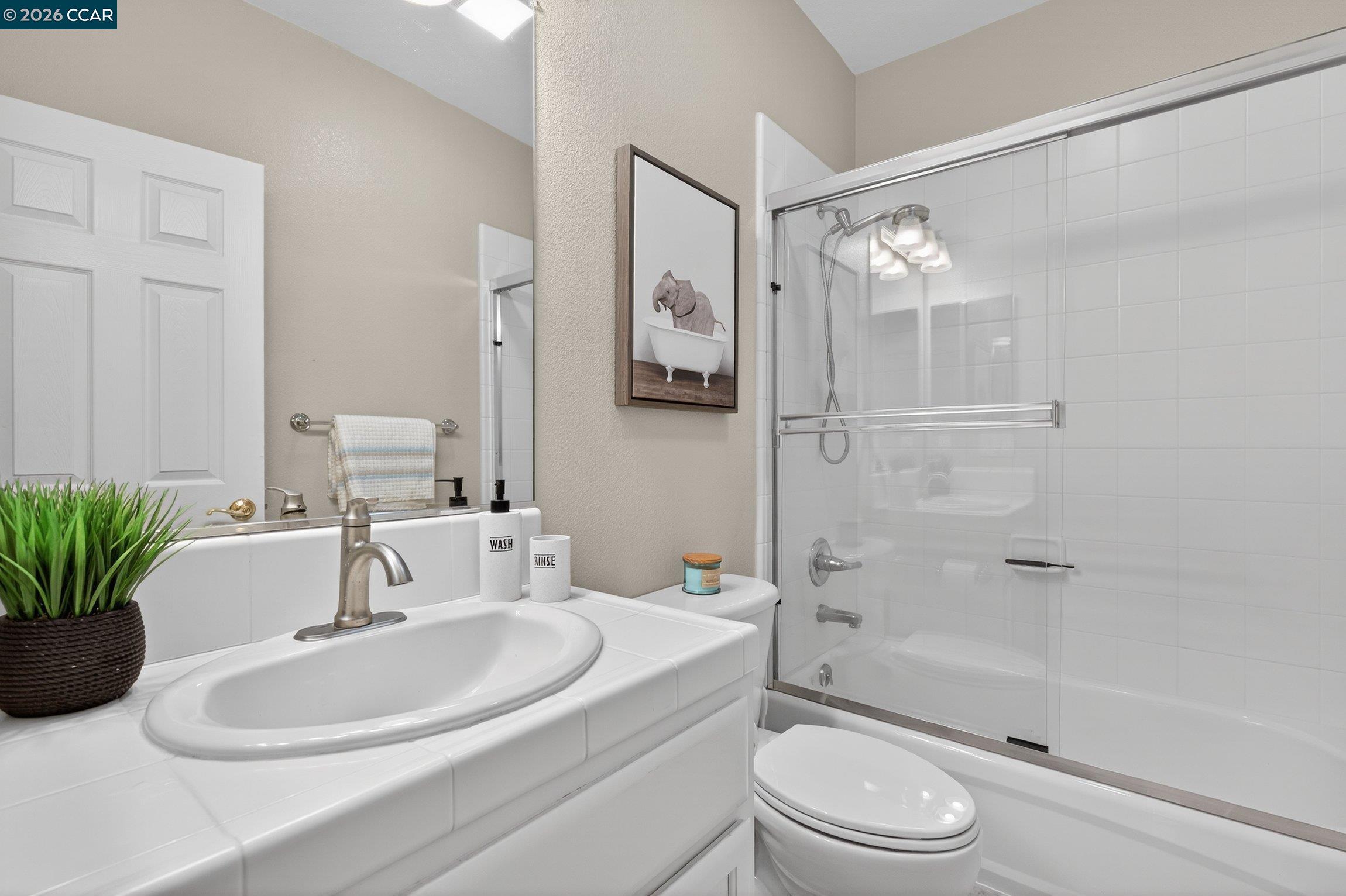 4300 Keegan Street Dublin, CA 94568 - Photo 23 of 33 a bathroom with a sink a toilet a glass door a shower and a mirror