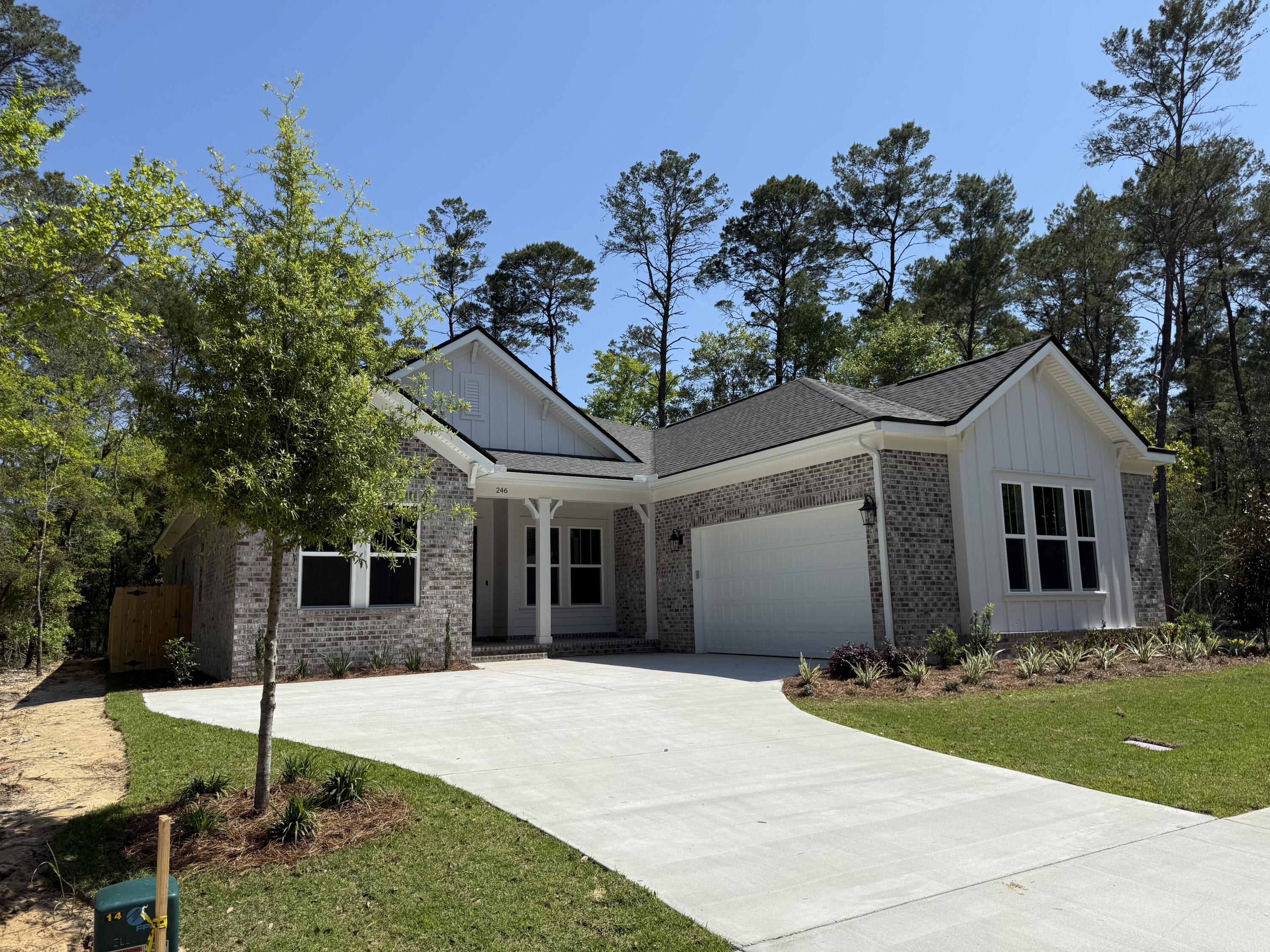 a view of a white house with a yard and potted plants