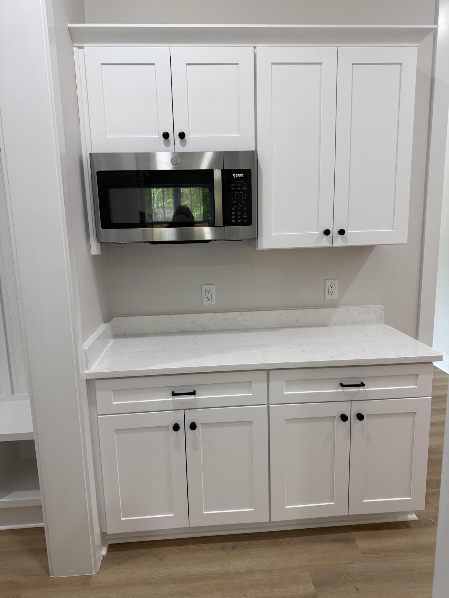 246 Foxglove Run Niceville, FL 32578 - Photo 14 of 40 a kitchen with white cabinets and a fireplace