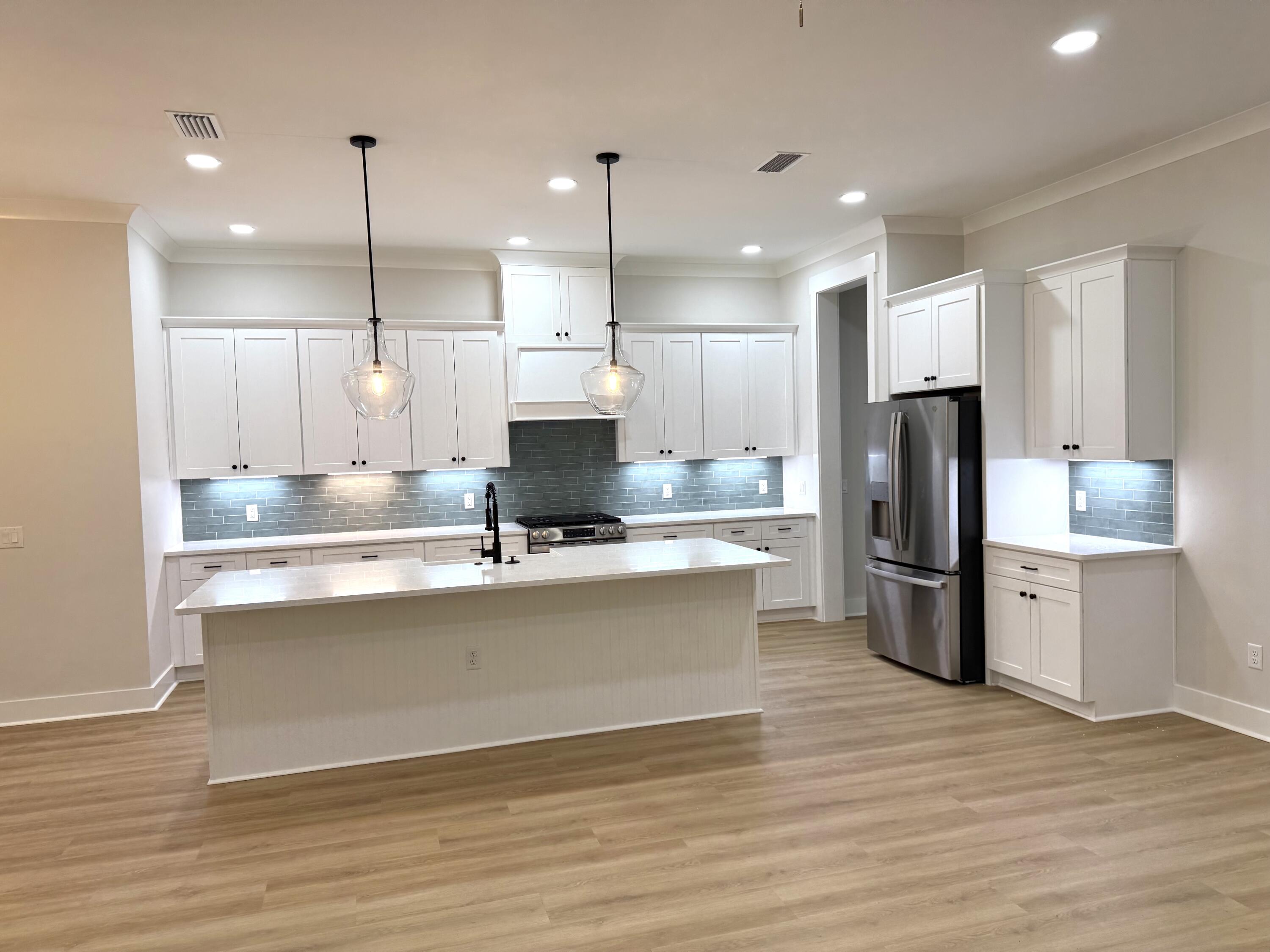 246 Foxglove Run Niceville, FL 32578 - Photo 8 of 40 a kitchen with stainless steel appliances granite countertop a refrigerator a sink dishwasher a stove and a refrigerator with wooden floor