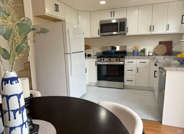 a kitchen with stainless steel appliances granite countertop a stove a microwave and cabinets