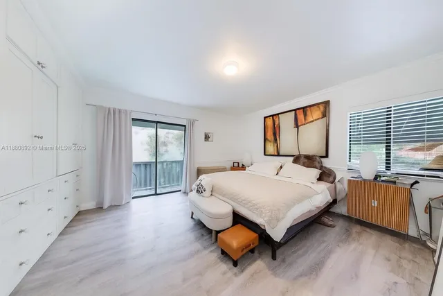 a bedroom with a bed and a dresser next to a window