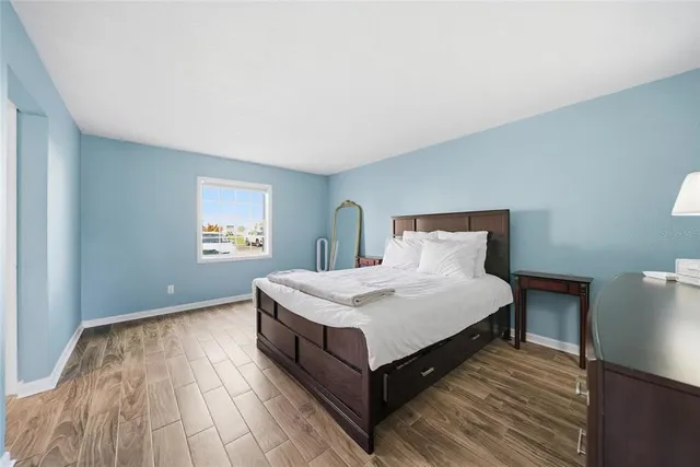 a bed sitting in a spacious bedroom next to a window