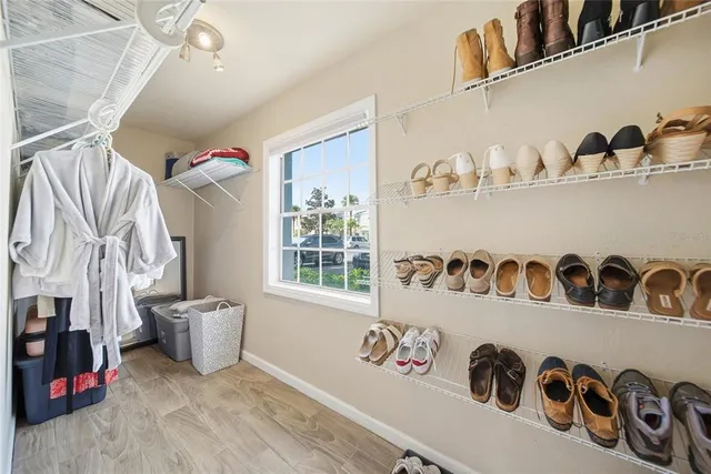 a view of walk in closet with clothes and shoes