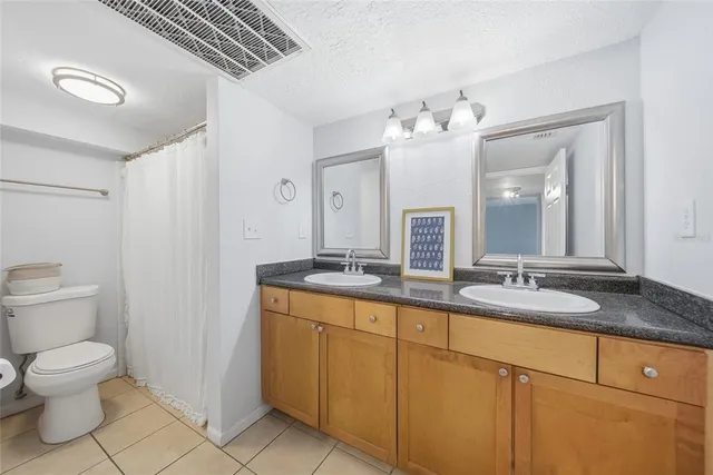 a bathroom with a granite countertop sink a toilet and a mirror