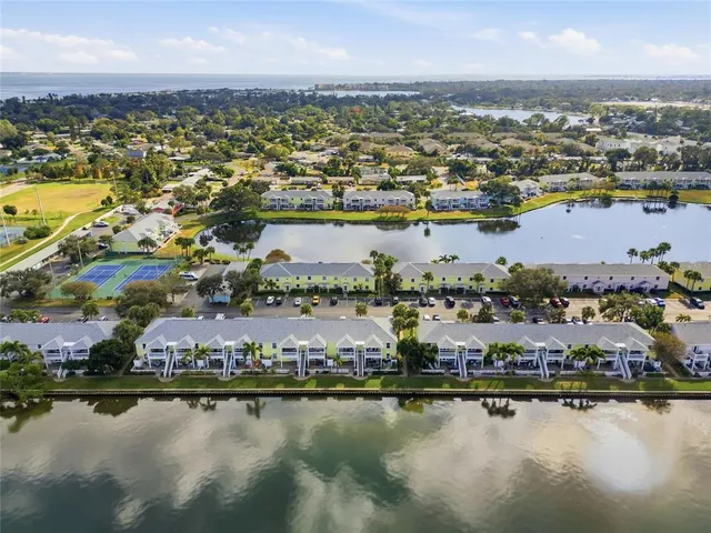 an aerial view of residential building ocean boats and trees